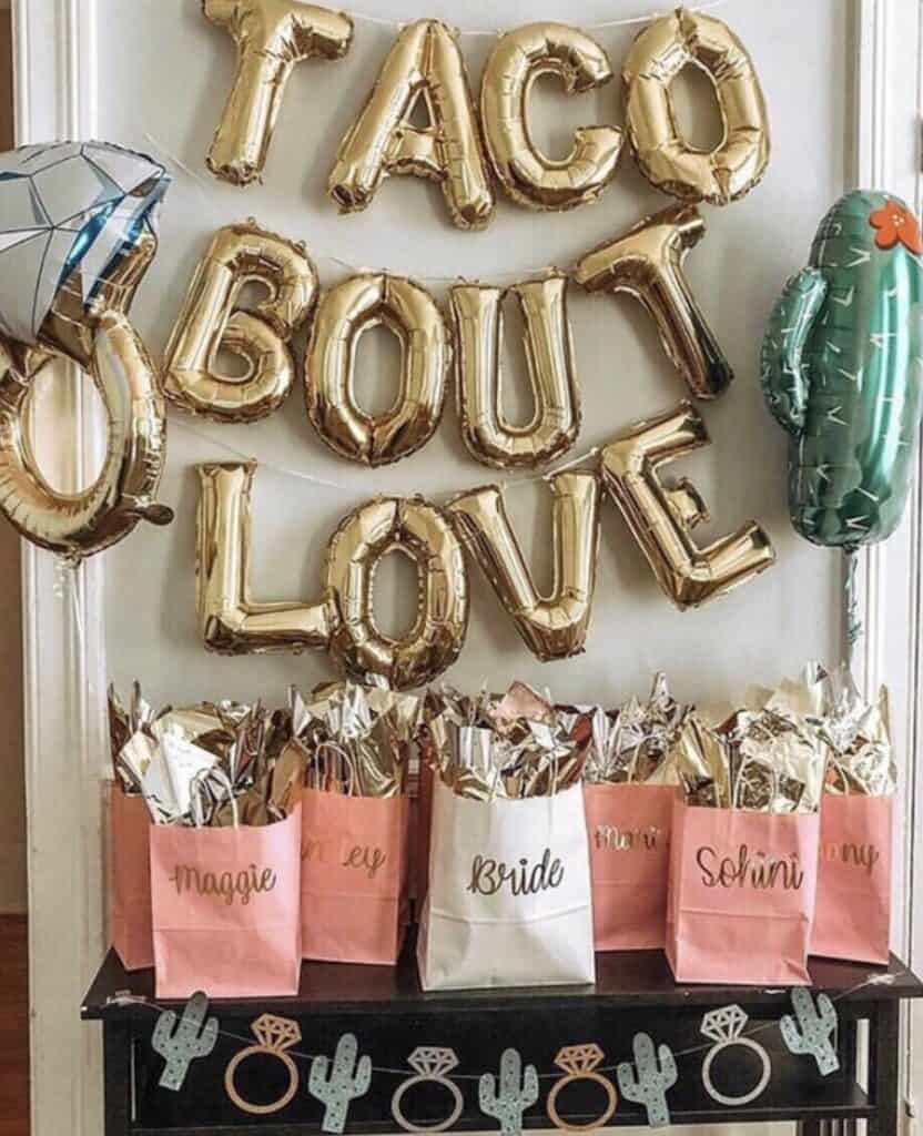 Confetti and roses birthday decoration with gold balloon letters.