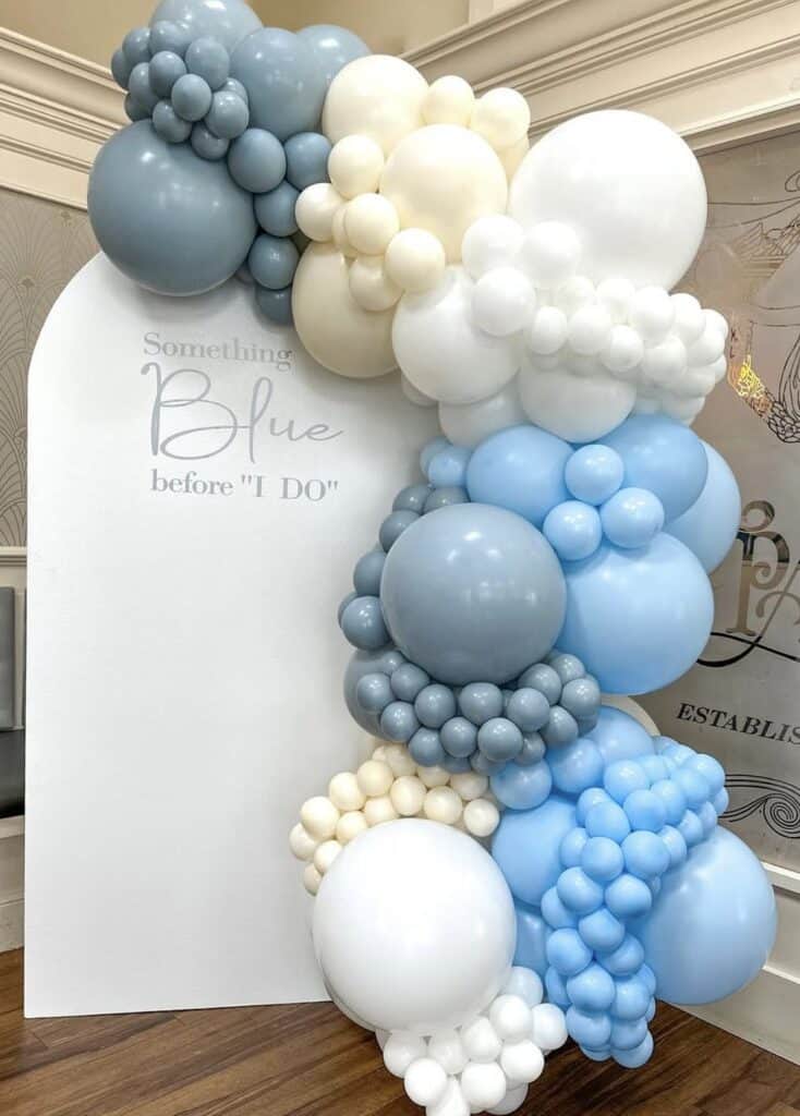 Colorful balloon arrangement with white, blue, and gray balloons for celebration.