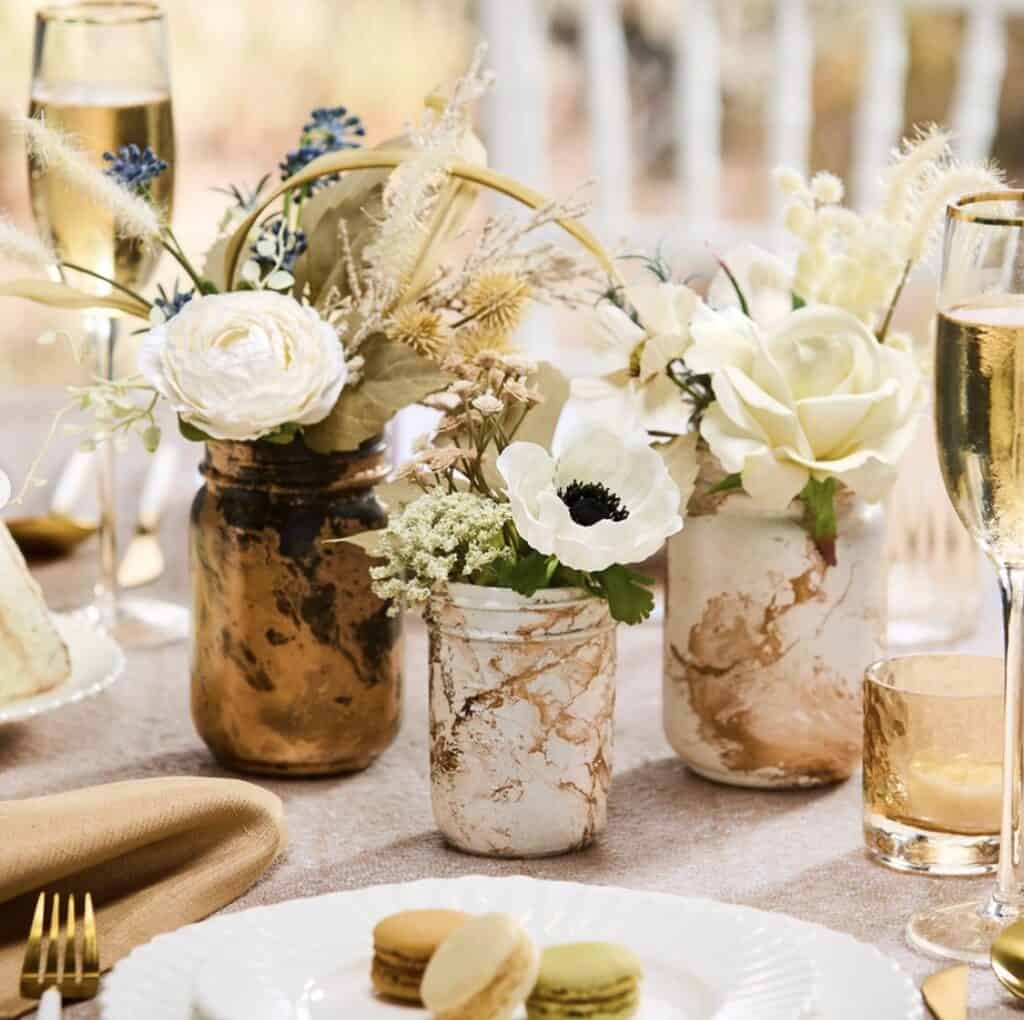 Elegant floral centerpiece with white roses and anemones for wedding decor.