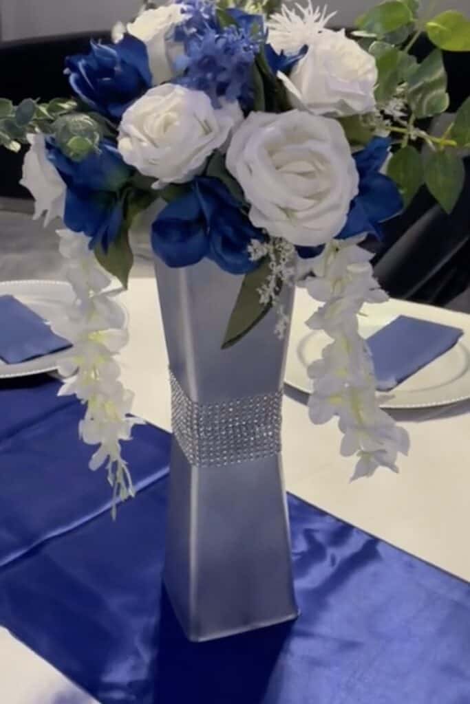 Elegant navy and white floral centerpiece with cascading orchids and roses.