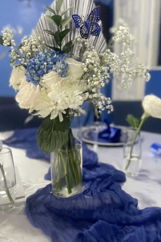 Blue and white floral centerpiece for wedding or event decor, elegant flower arrangement.