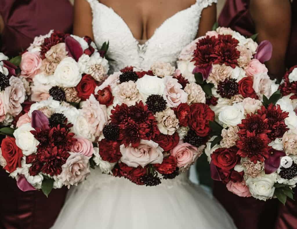 Bouquet of red, pink, and white roses and peonies for wedding floral arrangement.