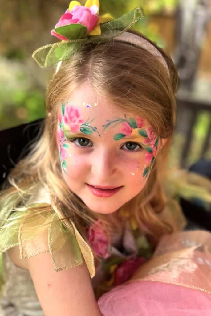 Brightly painted floral face art for children’s party costume, fairy or princess dress up.