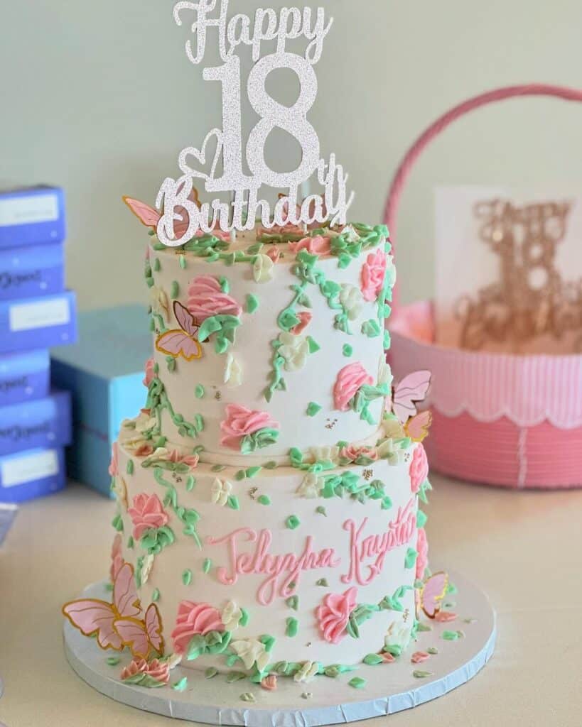 Colorful 18th birthday cake with pink, green, white frosting, butterfly decorations, and "Happy 18th Birthday" topper.
