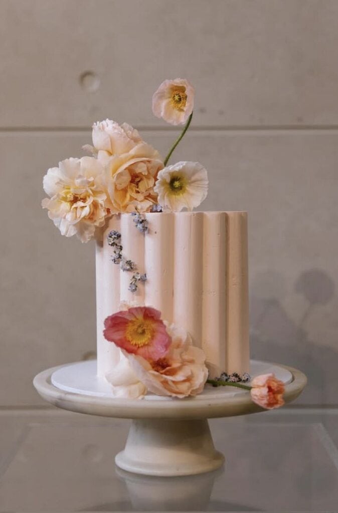 Elegant pastel floral cake with fresh flowers, perfect for weddings or celebrations.