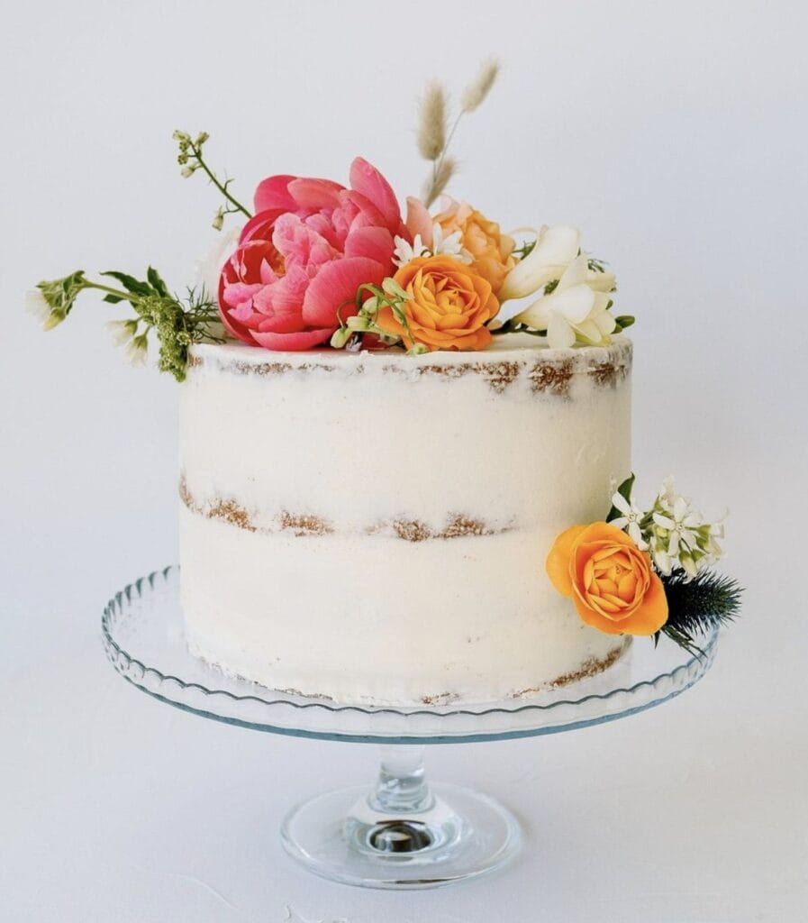 Vegan naked cake with fresh flowers for a wedding celebration.