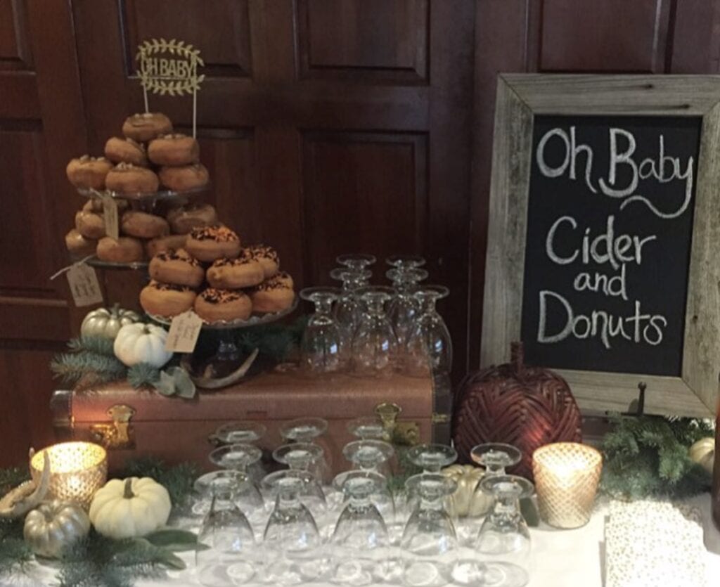 Fresh donuts with autumn decorations on a dessert table at Confetti & Roses.