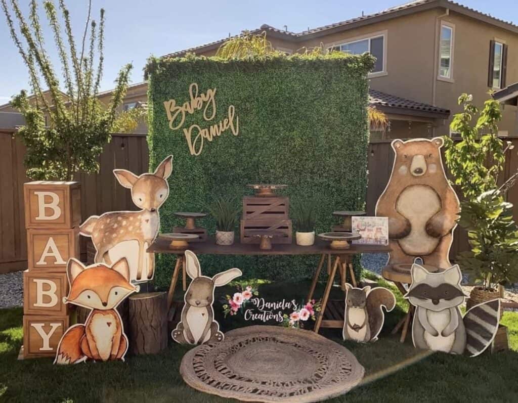 Colorful woodland-themed baby shower backdrop with cute animal cutouts and decorative elements.