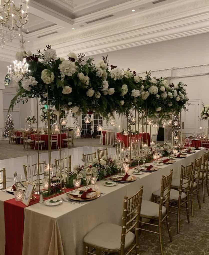 Elegant wedding reception table with floral centerpieces and gold accents.