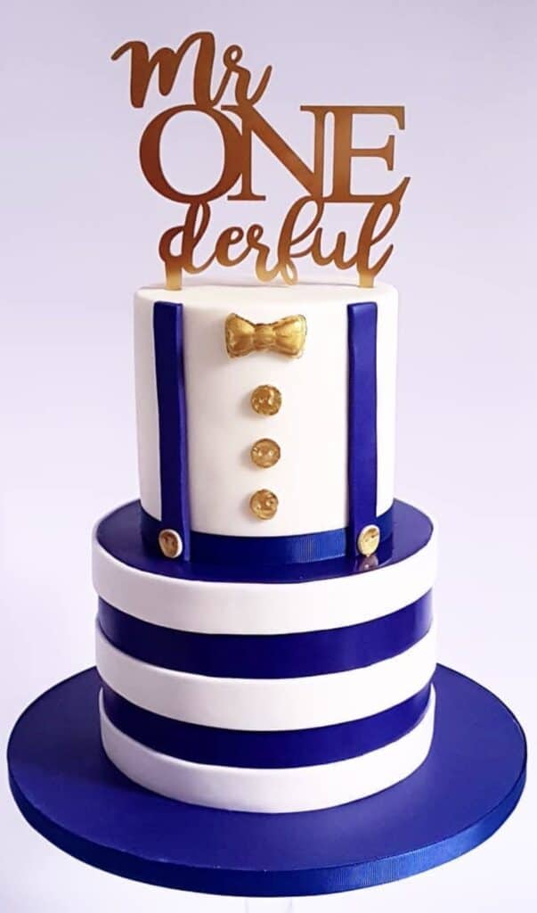 Confetti and roses happy birthday cake with navy blue stripes and gold accents.