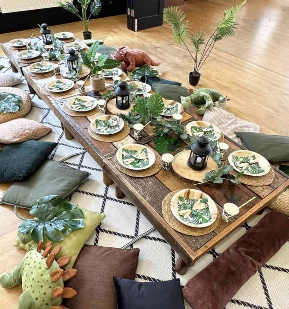 Lush jungle-themed dining table with tropical tableware and decorative plants.