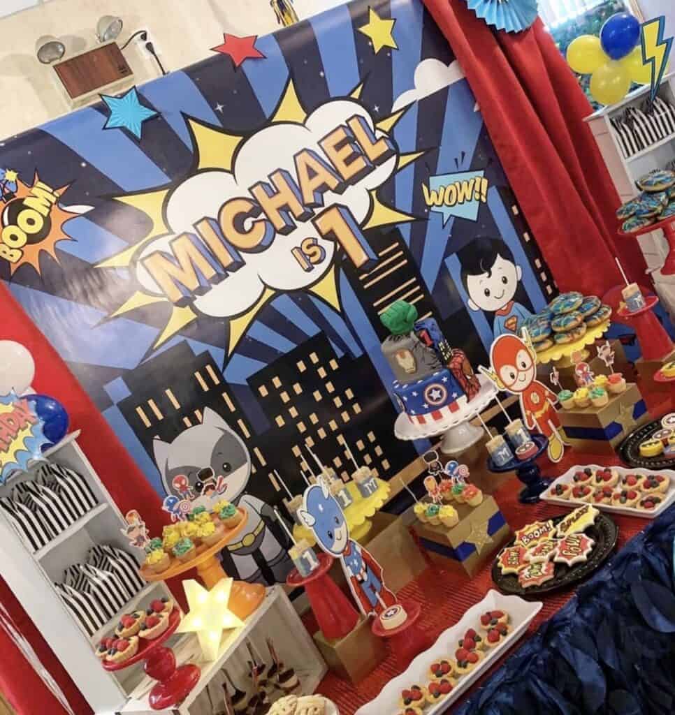 Colorful superhero-themed birthday party decoration for a child's first birthday celebration.
