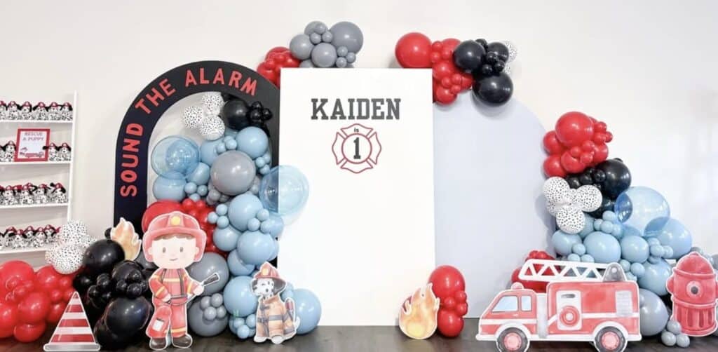 Colorful firefighter-themed balloon arch for kids birthday celebration.