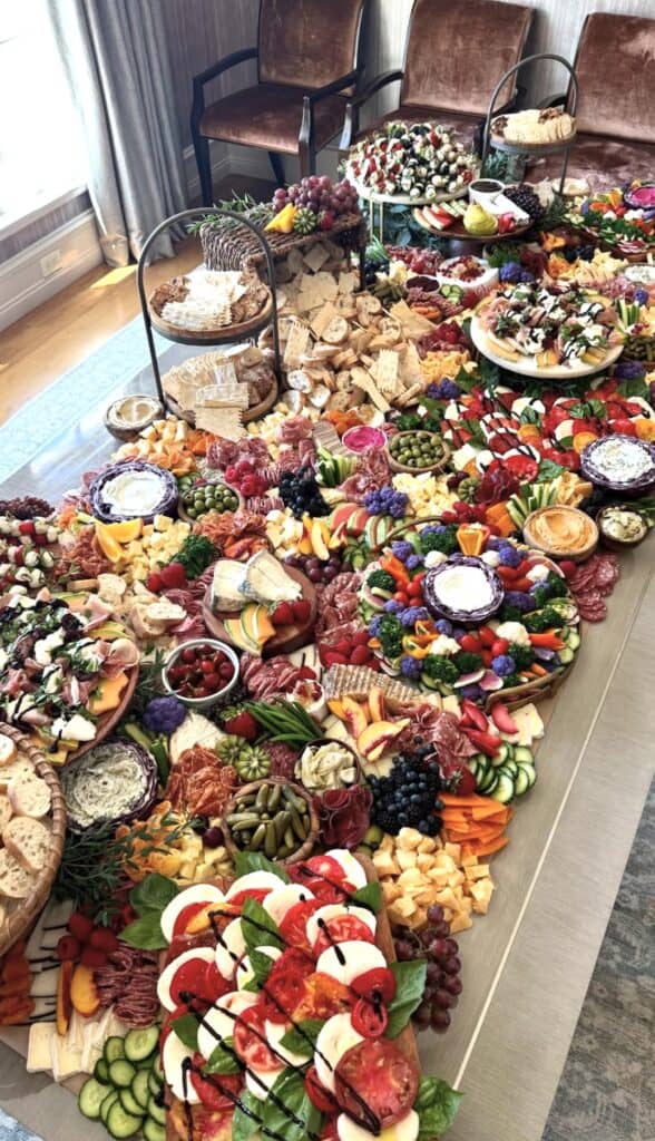 Colorful grazing table with cheese, fruits, vegetables, and charcuterie for special occasion.
