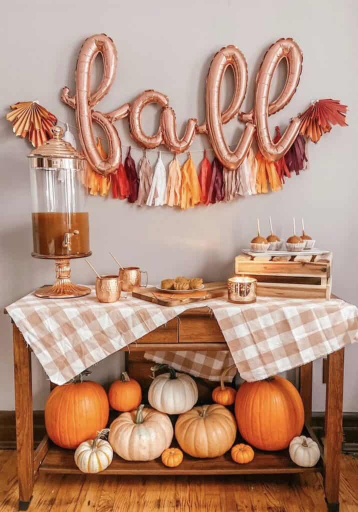 Colorful fall pumpkin display with "love" balloon banner and festive decor.