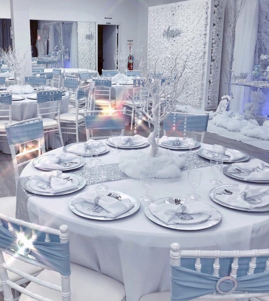 Elegant winter wedding reception decorated with white trees and snow-themed details.
