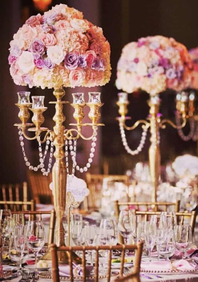 Elegant floral centerpiece with pink and purple roses for wedding decor.