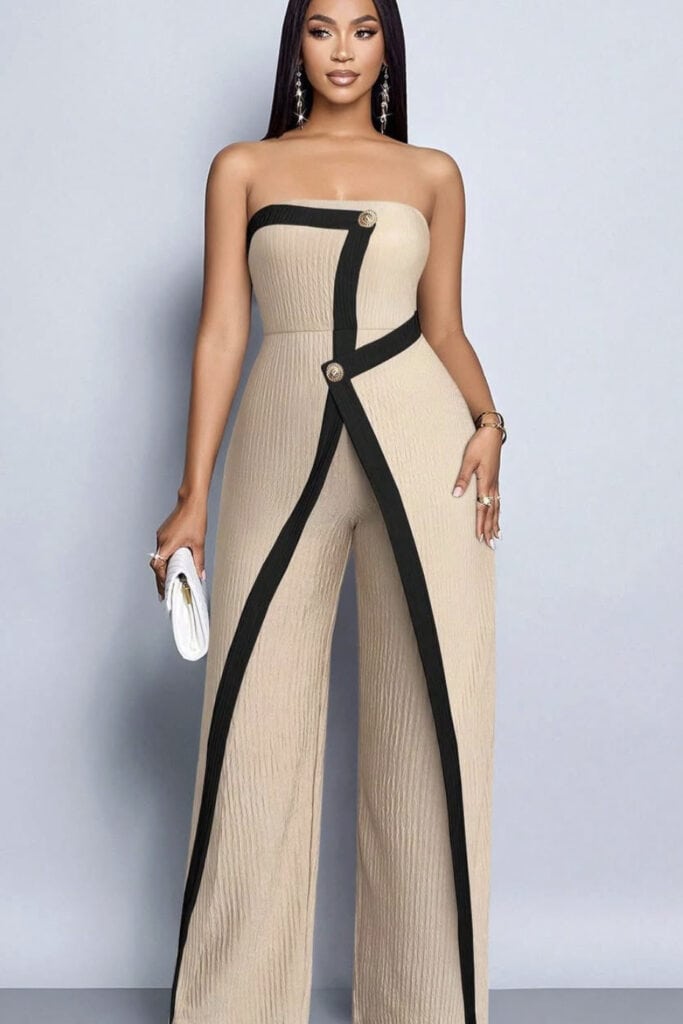 Elegant beige strapless jumpsuit with black trim and decorative buttons, fashionable women's outfit.