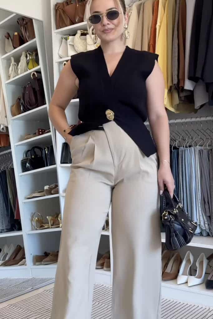 Stylish woman's outfit with black sleeveless top and beige wide-leg pants, fashion accessories, shopping boutique scene.
