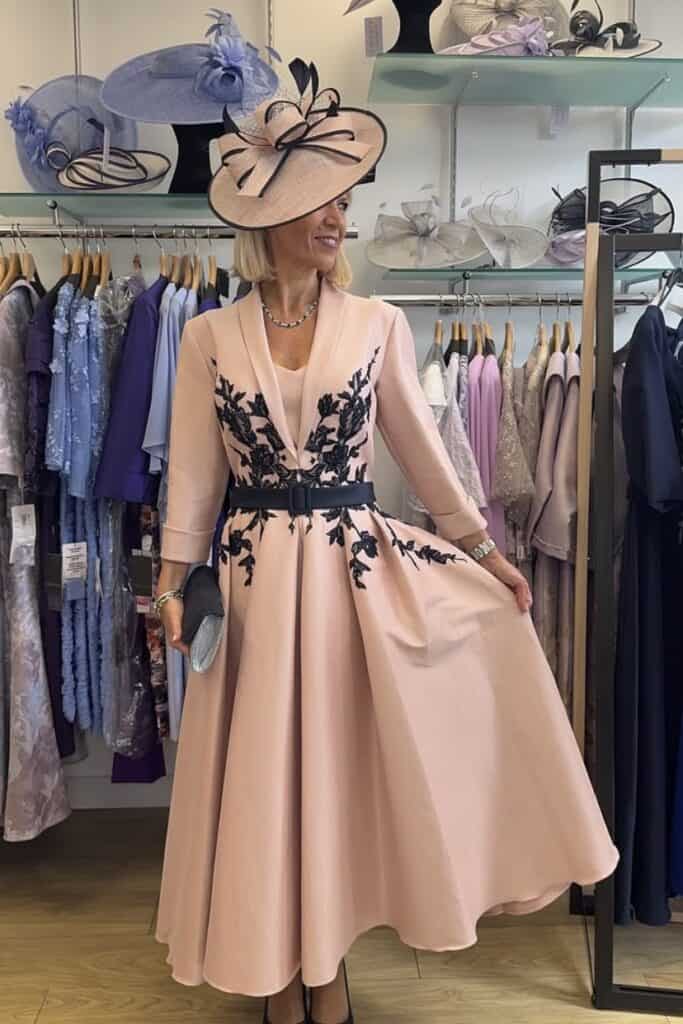 Elegant blush pink dress with black floral embroidery at Confetti & Roses store.