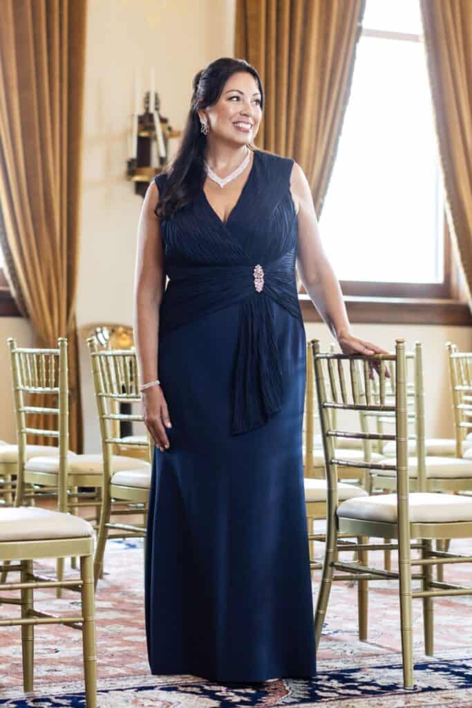 Elegant woman in navy evening gown at formal event.