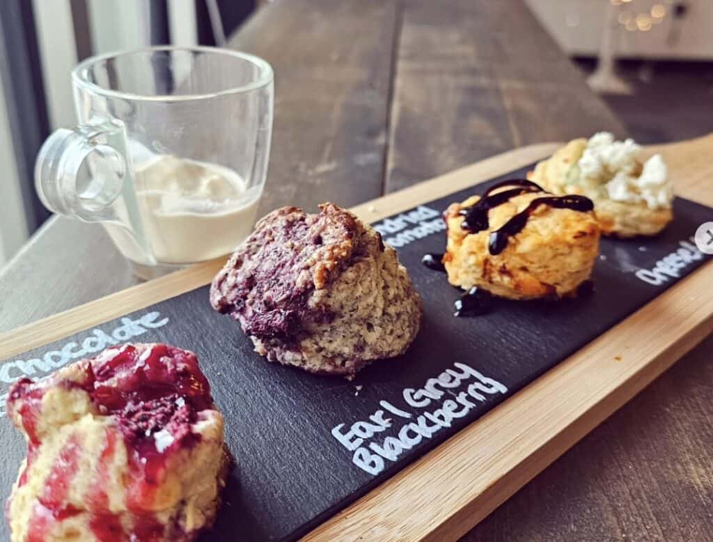 Assorted scones and cream on a chalkboard tasting platter at Confetti & Roses.