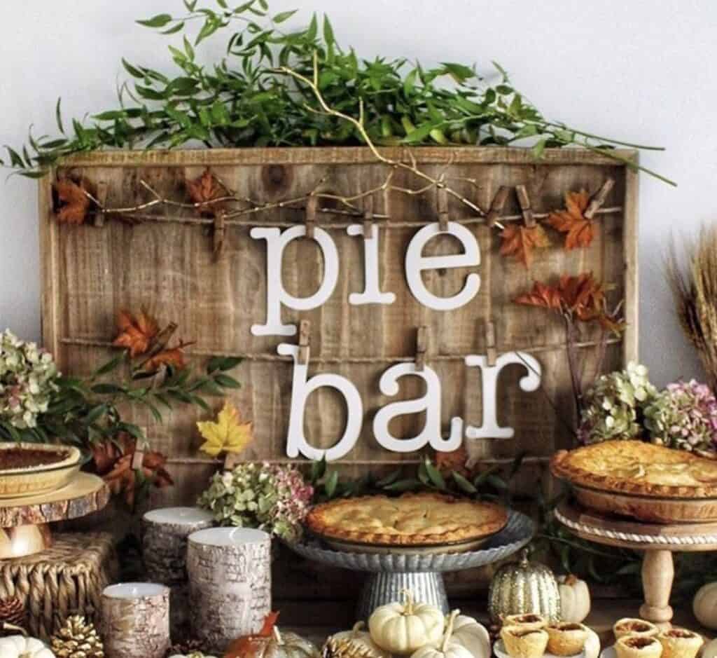 Cozy fall-themed dessert table with pumpkin pies and rustic decor for seasonal celebration.