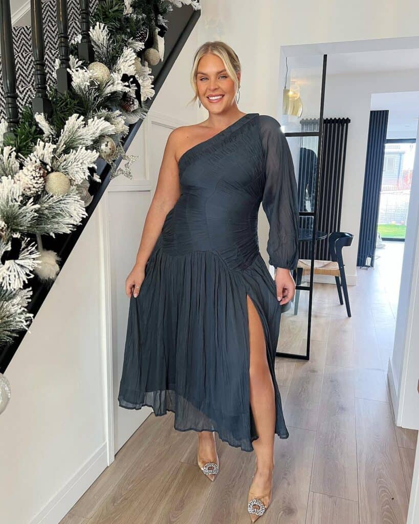 Elegant black one-shoulder dress with high slit, stylish for special occasions.