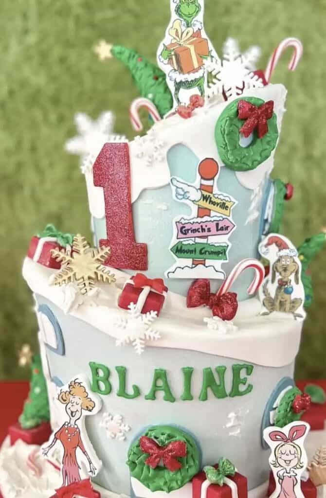 Festive Christmas cake with Grinch and holiday decorations, candy canes and presents.