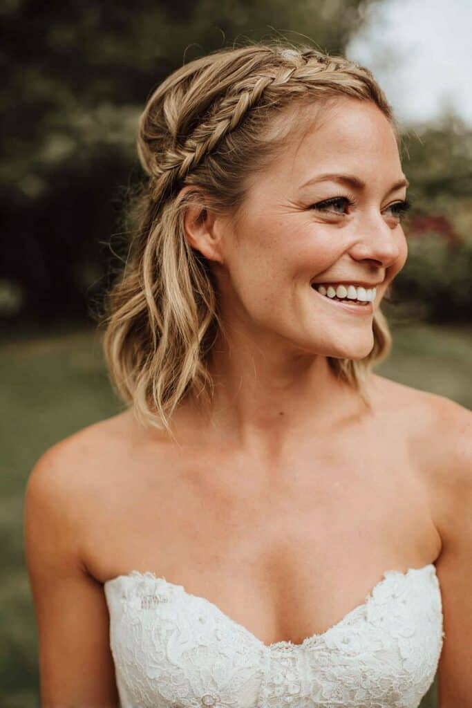 Bright smiling woman with bridal hairstyle and strapless wedding dress, outdoor portrait.