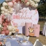 Balloon arch with pink, white, and gold balloons for winter wonderland party.