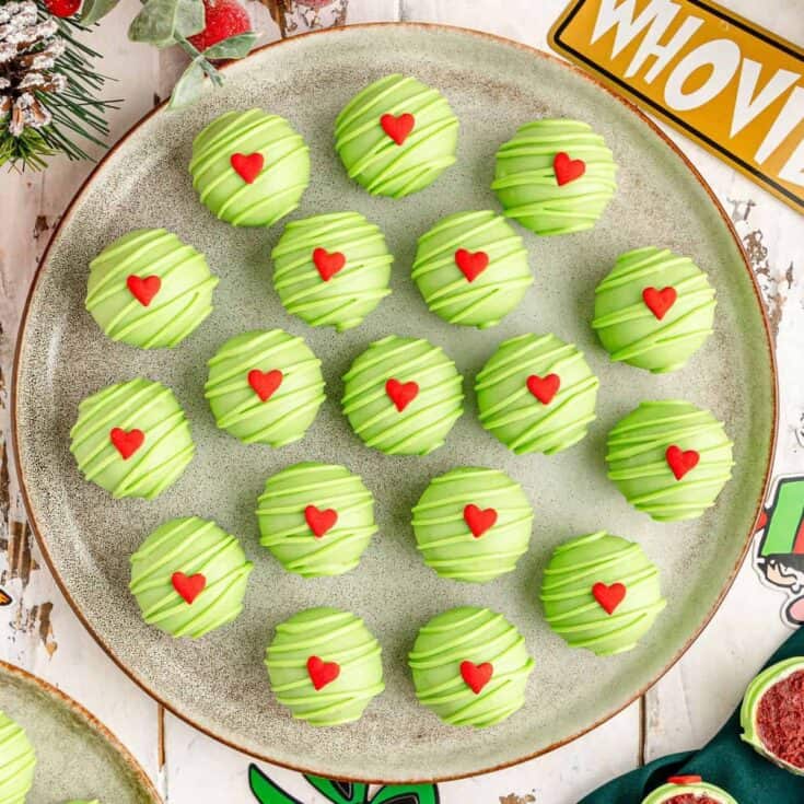 Vegan matcha green tea truffles with red heart sprinkles on a serving plate.