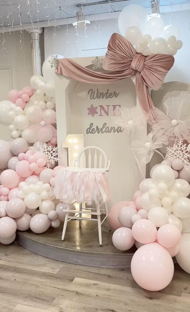 Pink and white balloon arrangement for winter baby shower decor.