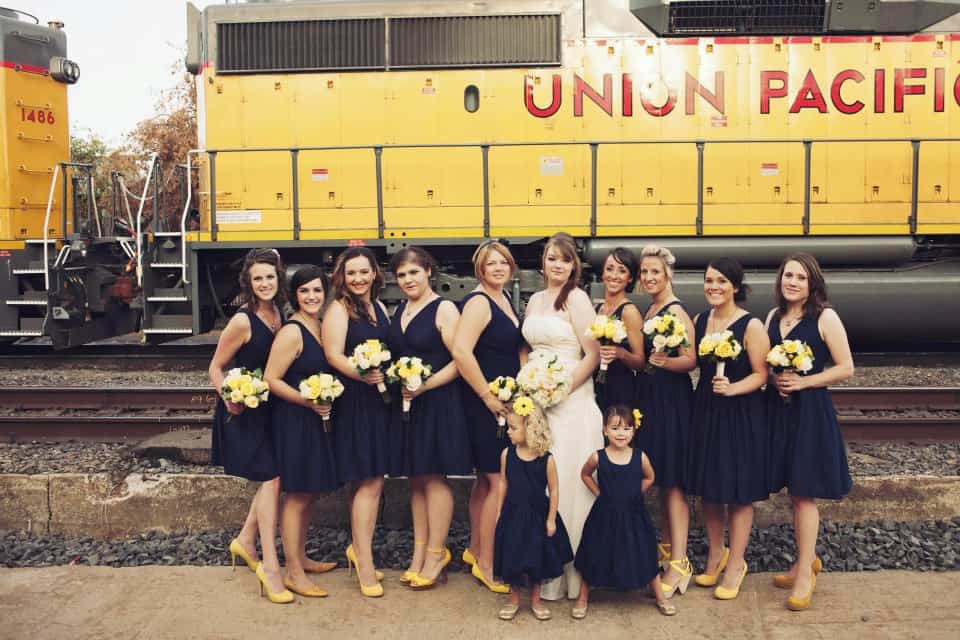 Colorful bridesmaids and flower girl wedding attire with Union Pacific train in background.