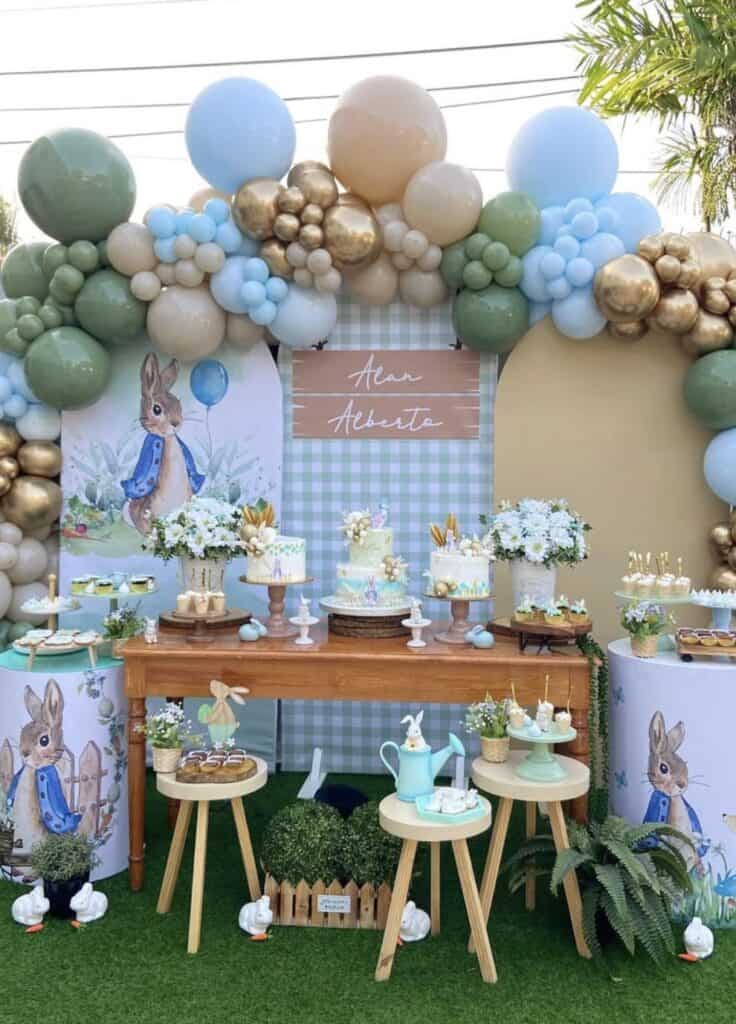 Colorful bunny themed birthday party with balloon arch and floral decorations.