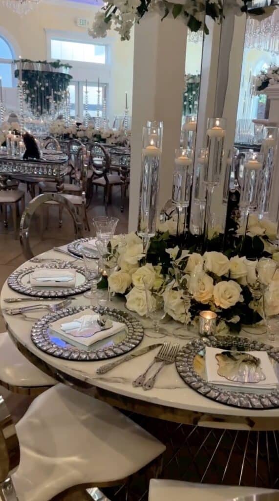 Elegant wedding table setting with white roses and crystal candleholders.