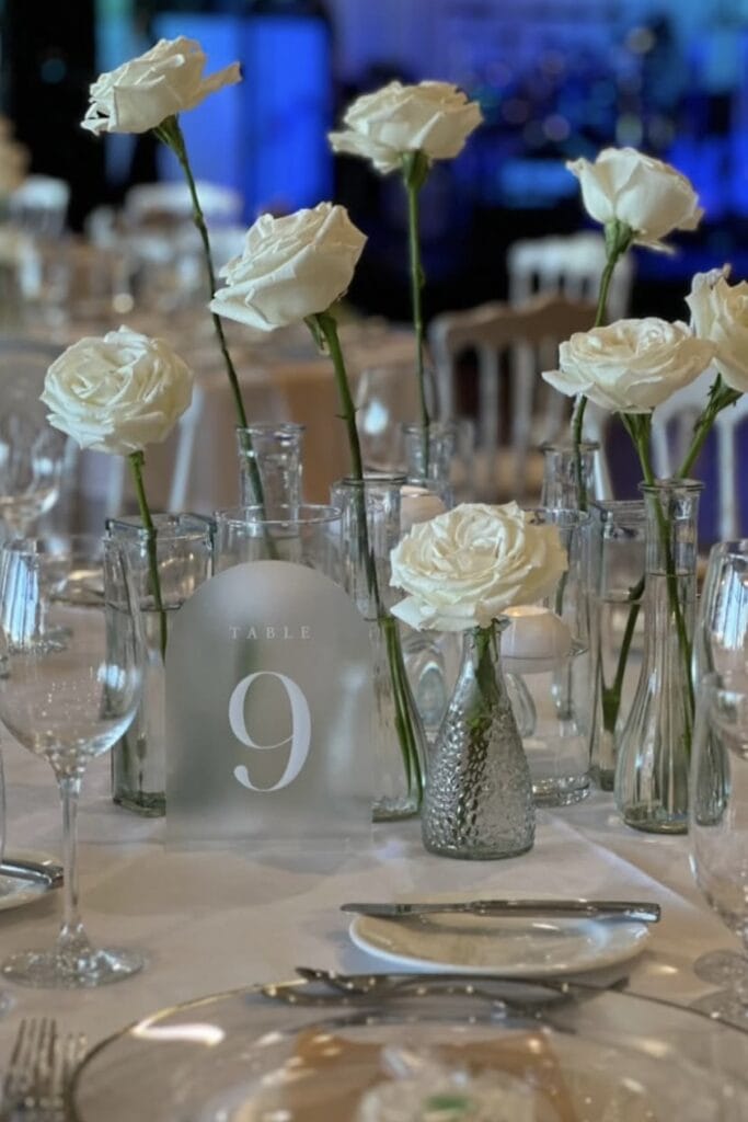 Elegant white rose floral centerpiece for wedding tables.