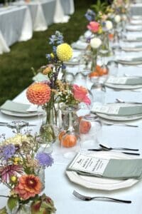 Colorful floral wedding table centerpiece with fresh flowers and elegant place settings.
