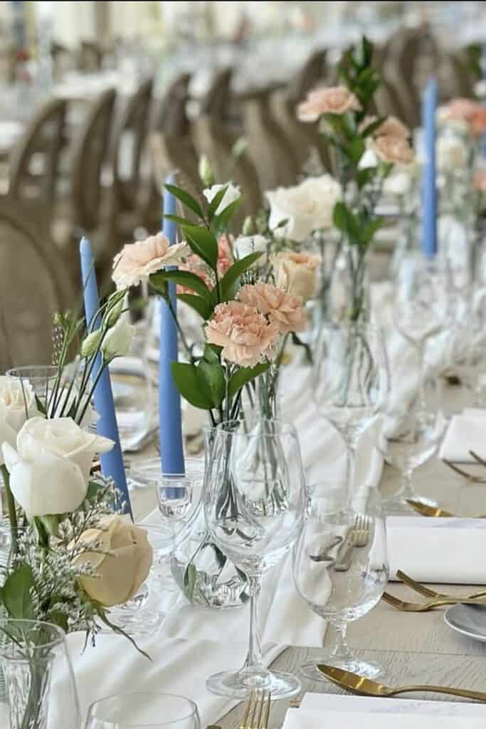 Elegant floral centerpiece with pastel roses and greenery for wedding decor.