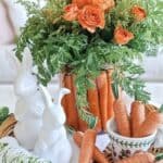 Bright orange roses and fresh greenery in a stylish floral arrangement, spring decor centerpiece.
