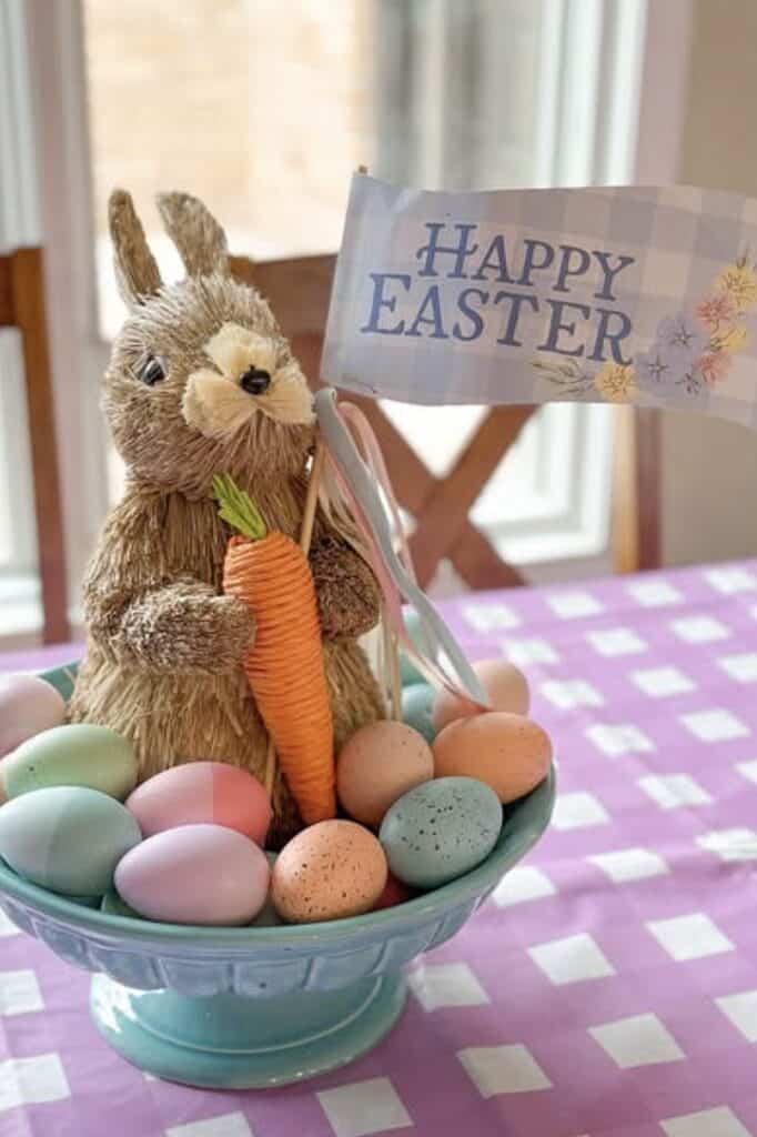 Colorful Easter decoration with bunny figurine, decorated eggs, and "Happy Easter" flag.