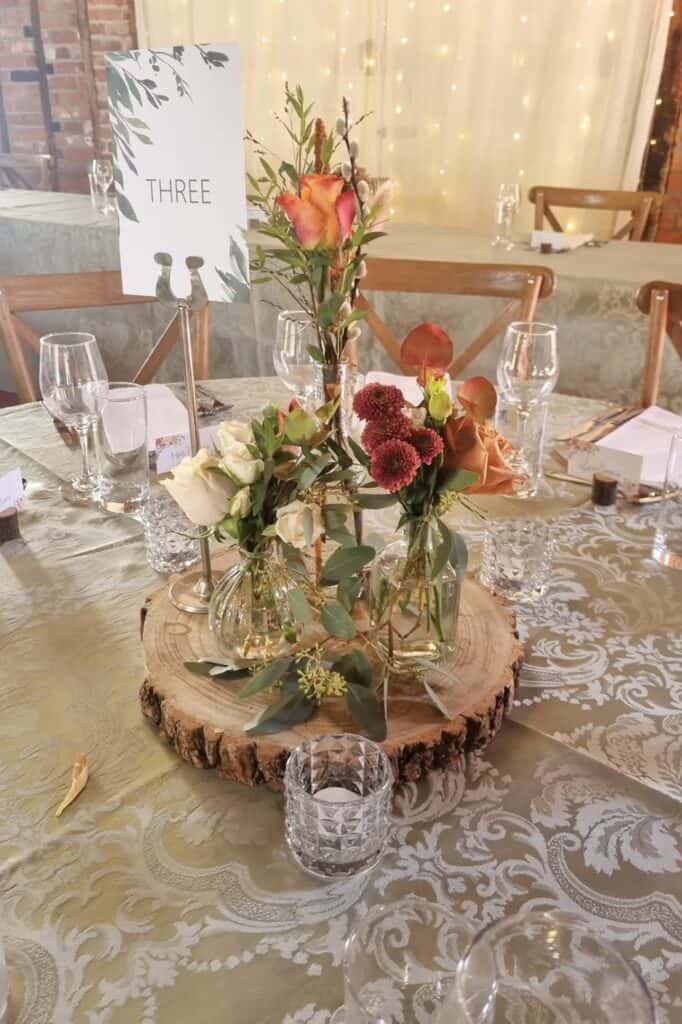 Elegant floral centerpiece with roses, eucalyptus, and autumn blooms for wedding decor.