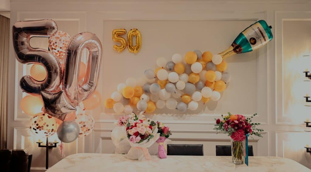 50th birthday yellow and white balloons on table