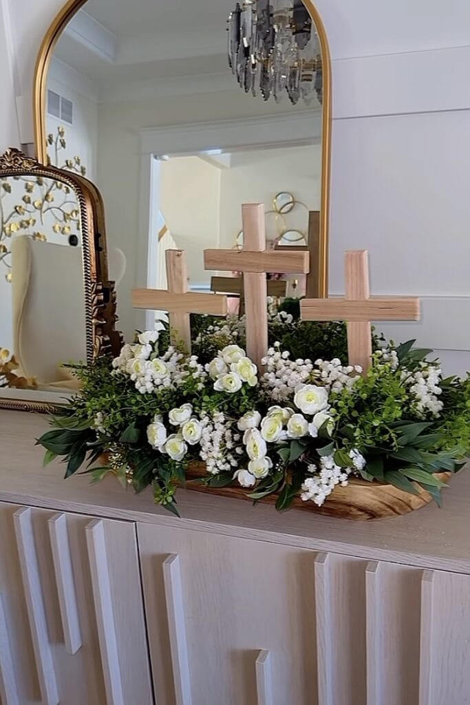 Elegant floral arrangement with wooden crosses for funeral or memorial service.