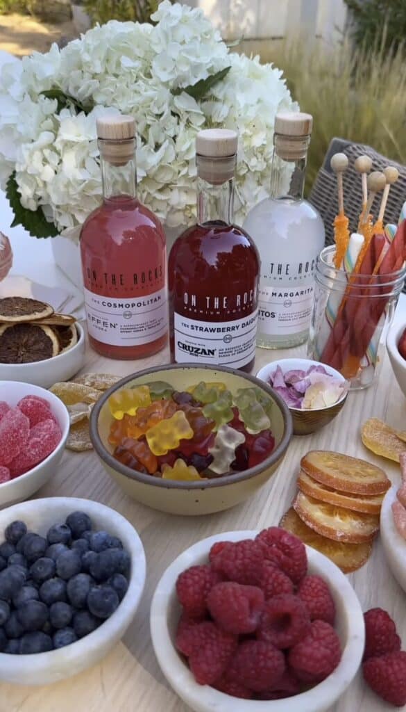 Bright floral centerpieces with white hydrangeas and colorful party treats for celebration.