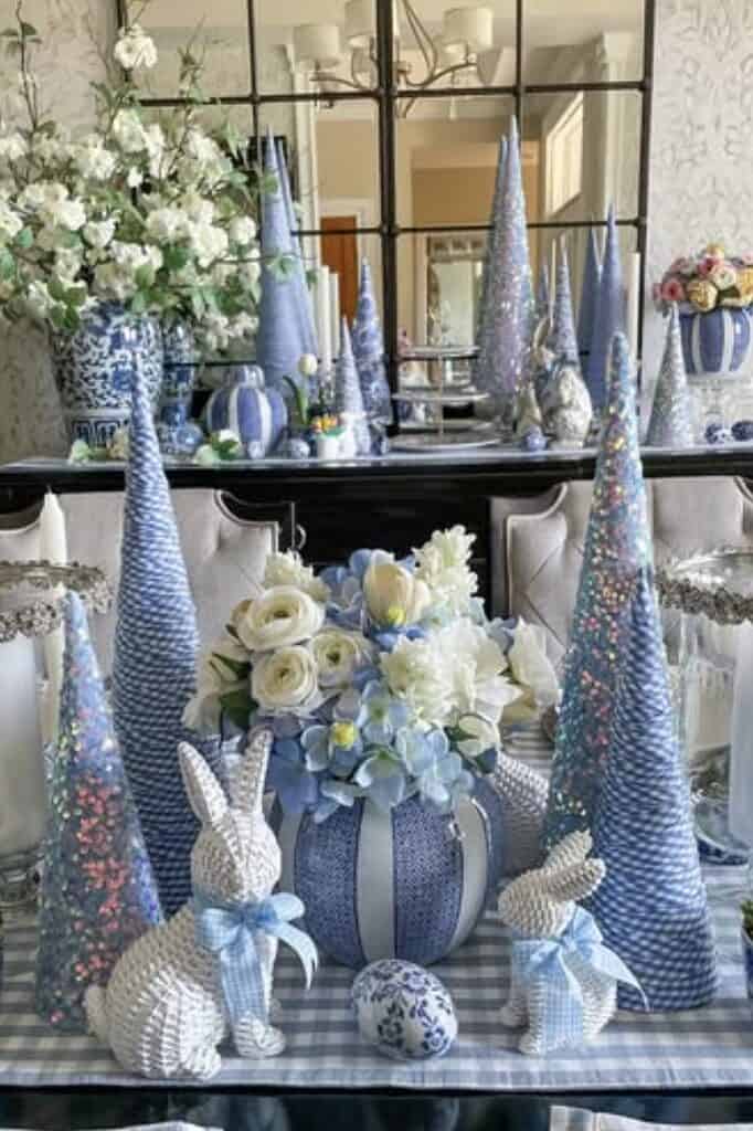 Colorful Christmas table decor with blue and white accents, Easter bunnies, flowers, and ornaments.