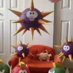 A colorful DIY Mario-themed birthday party decoration with spiky purple and red paper lanterns resem.