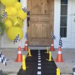 Mario Kart themed birthday party entrance with race track, balloons, and checkered flags.