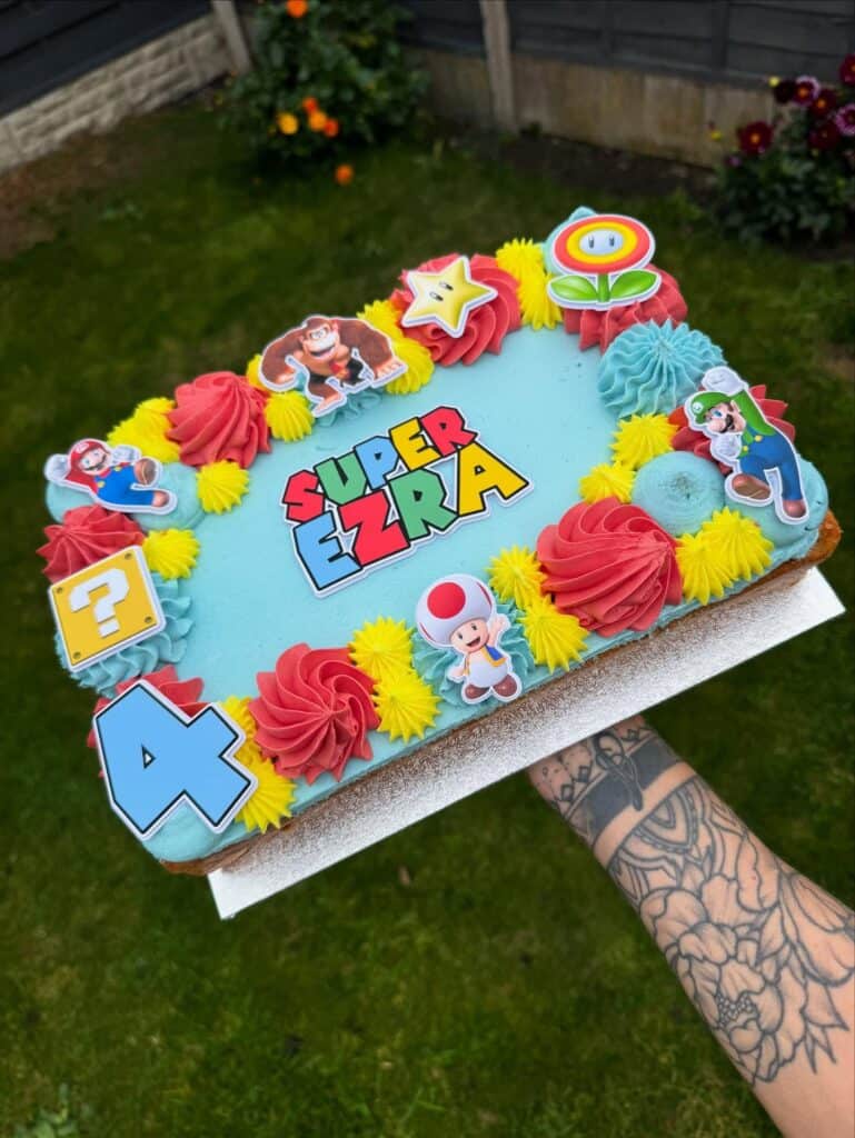 Super Mario-themed birthday cake with colorful decorations and characters for kids' celebration.