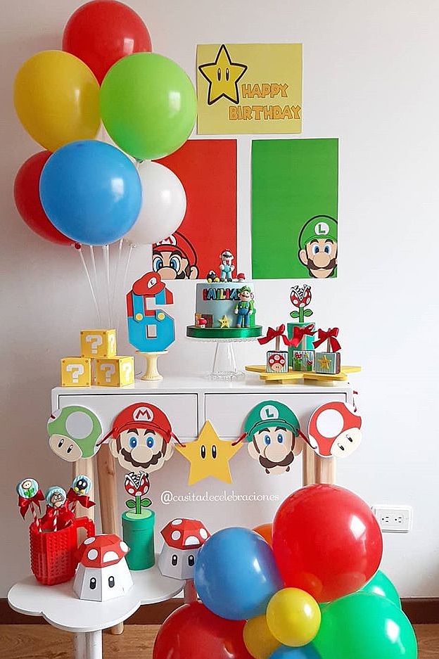 Mario-themed birthday party decorations with balloons, cake, and Super Mario characters.